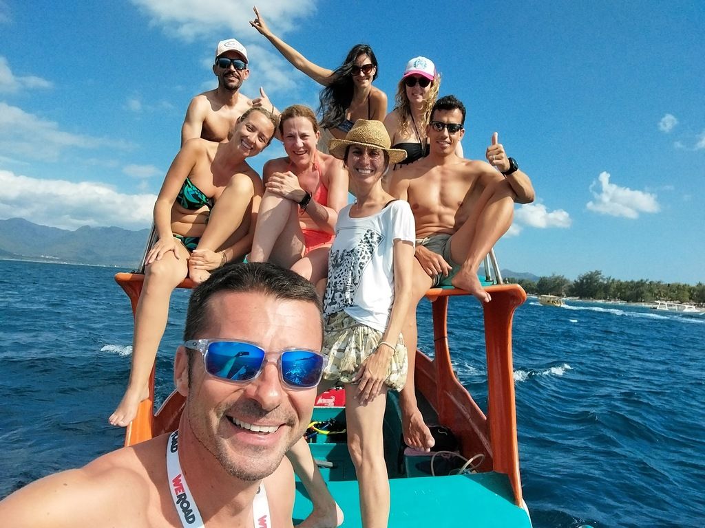 Eine fröhliche WeRoad-Gruppe auf einem Boot während einer Gruppenreise nach Bali, lächelnd und das Abenteuer genießend.