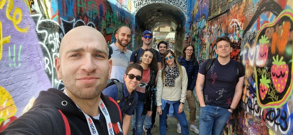 Gruppenfoto während einer WeRoad-Gruppenreise nach Brüssel, Belgien, aufgenommen in einer bunten, graffiti-bedeckten Gasse.