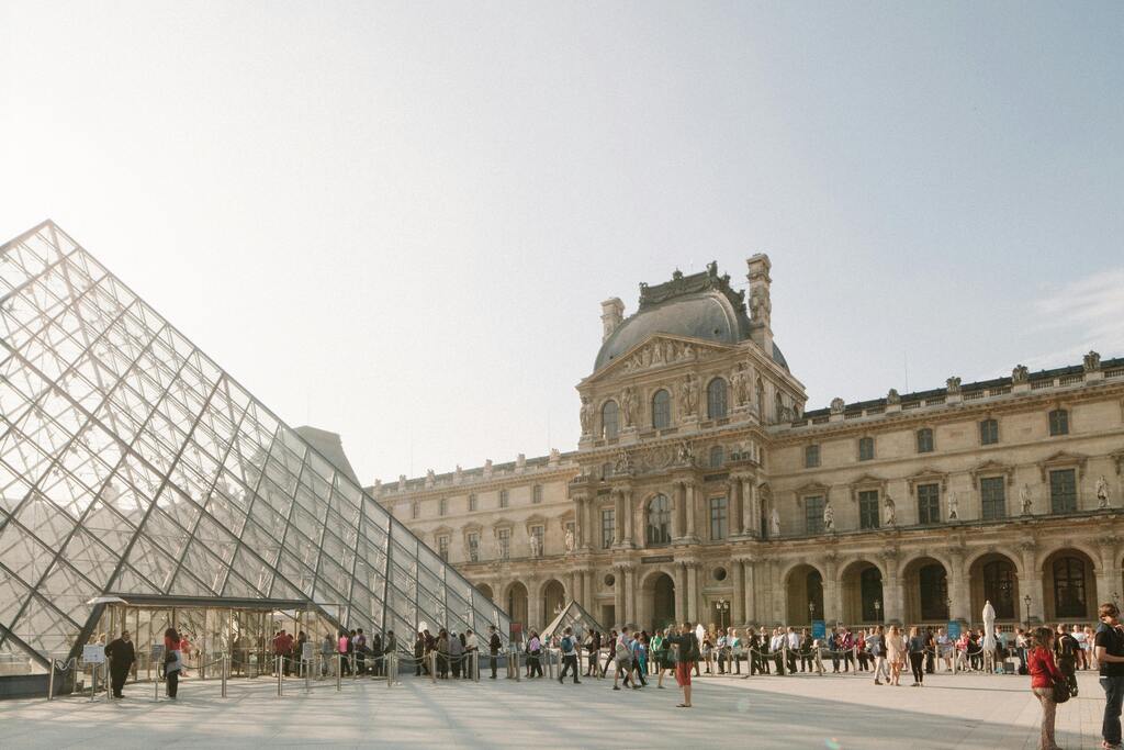 Glas-Pyramide und das Louvre-Museum mit Menschen, die in der Schlange stehen.