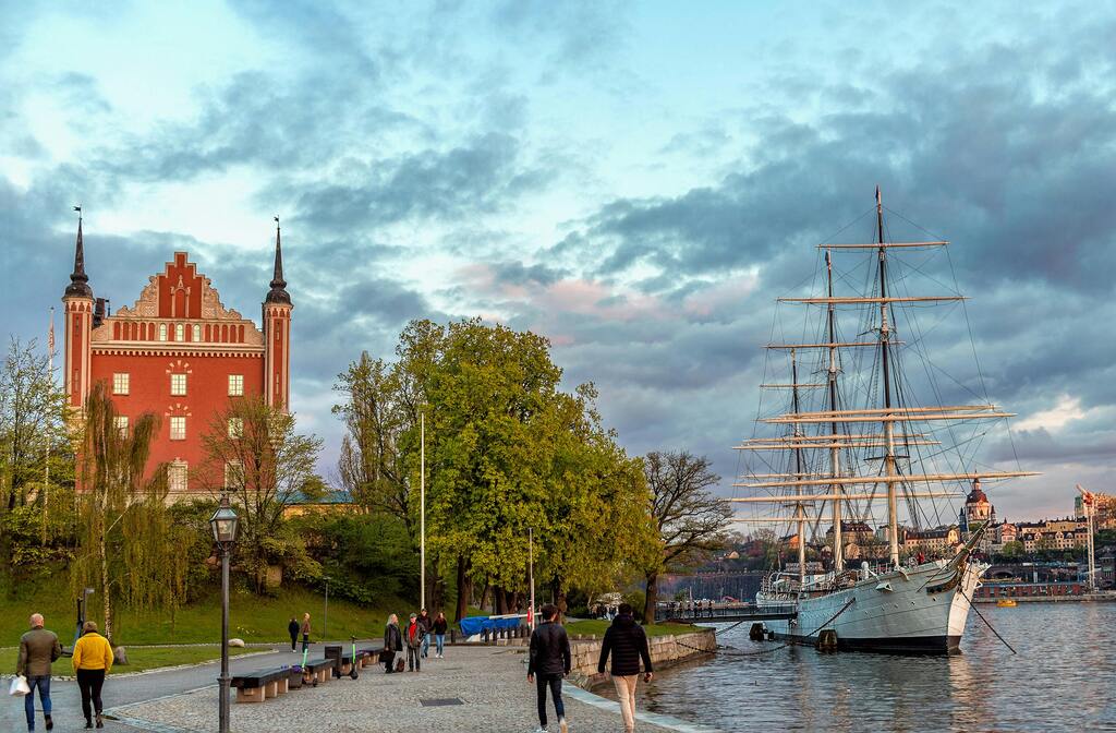 Malerische Abendstimmung in Stockholm mit einem historischen Segelschiff am Wasser.
