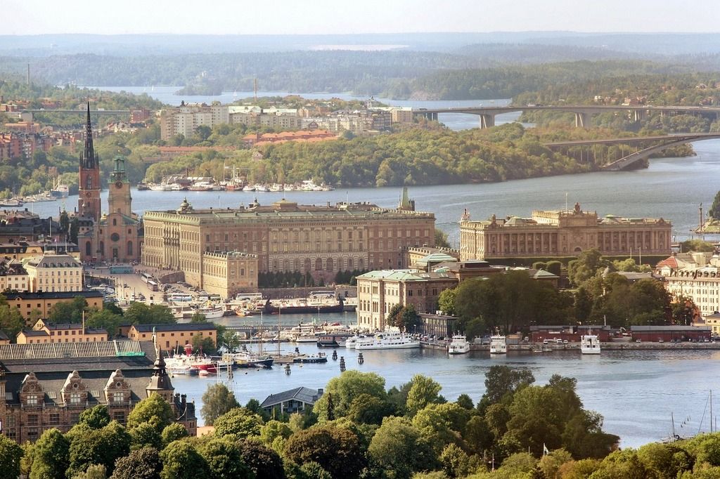 Luftaufnahme des Königspalastes und der Altstadt von Stockholm, umgeben von Wasser und Brücken.
