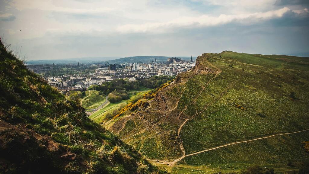 Arthur’s Seat, ein Panoramablick auf Edinburgh von einem grünen Hügel aus.