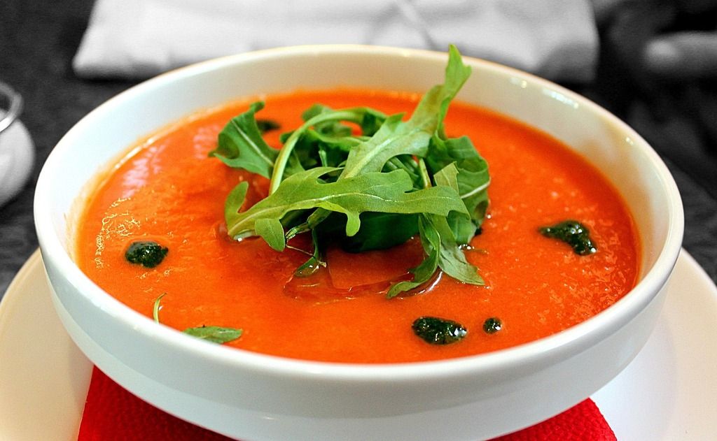 Schüssel mit Gazpacho, einer kalten spanischen Tomatensuppe, garniert mit Rucola.