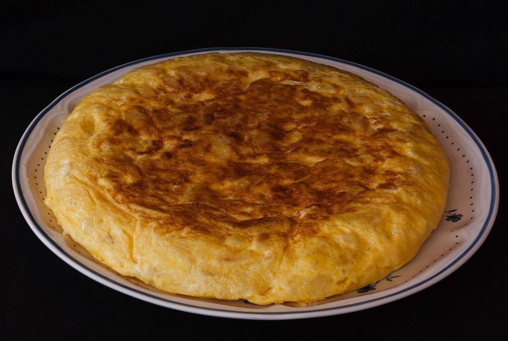 Spanisches Essen: Spanische Tortilla, ein klassisches Kartoffel-Omelett, auf einem Teller präsentiert.