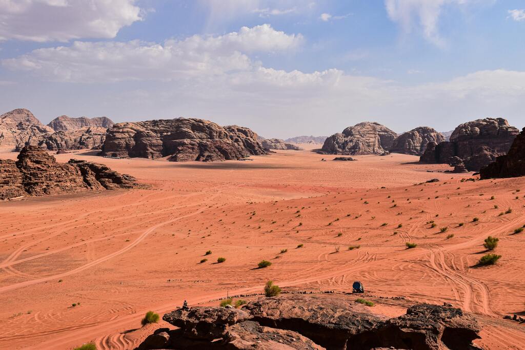 Weite Sanddünen und Felsen in der endlosen Landschaft des Wadi Rum