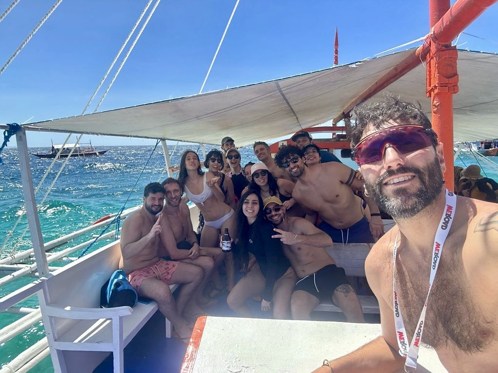 WeRoad-Gruppenreise auf einem traditionellen philippinischen Boot im sonnigen Meer.