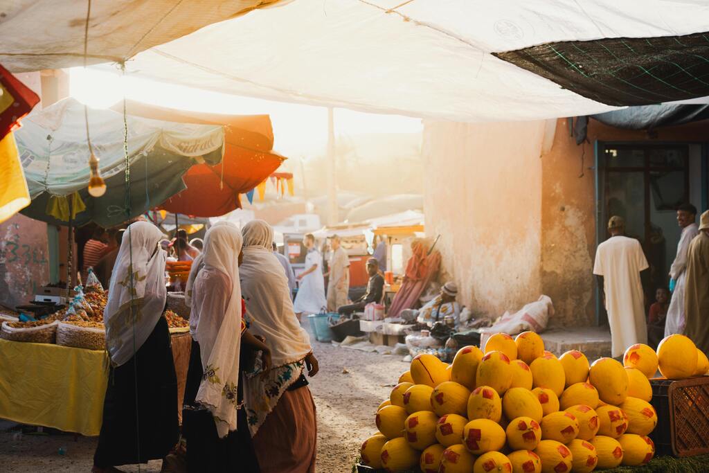 Ein belebter Markt in Marokko mit frischem Obst, Gewürzen und traditionellen Produkten.