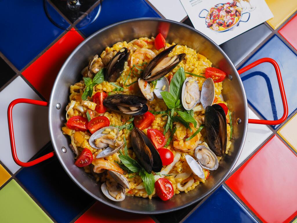 Traditionelle spanische Paella mit Meeresfrüchten in einer großen Pfanne serviert.