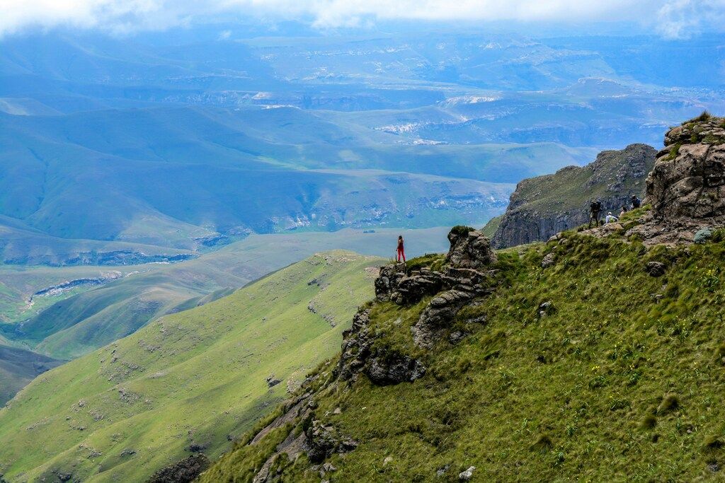 Wanderer auf einem grünen Hochplateau mit Blick auf das Tal