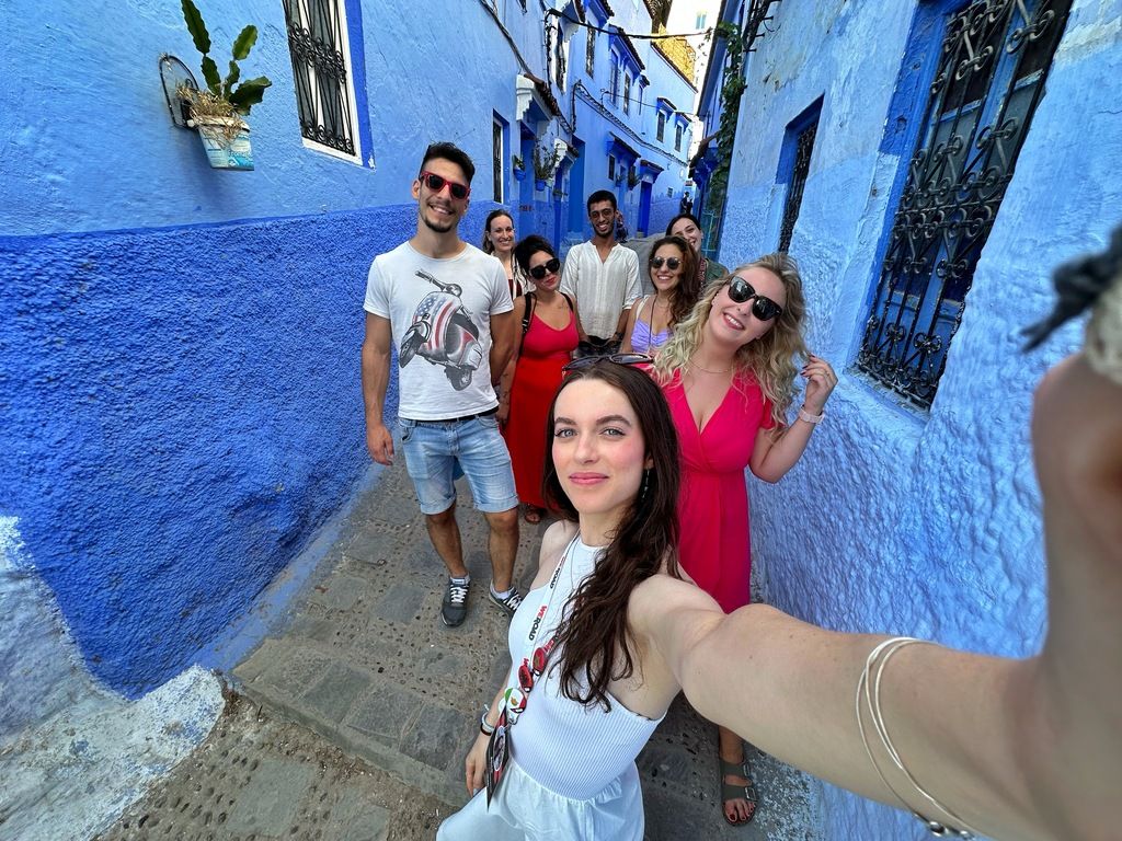 WeRoad Gruppe macht ein Selfie in den blauen Gassen von Chefchaouen, Marokko