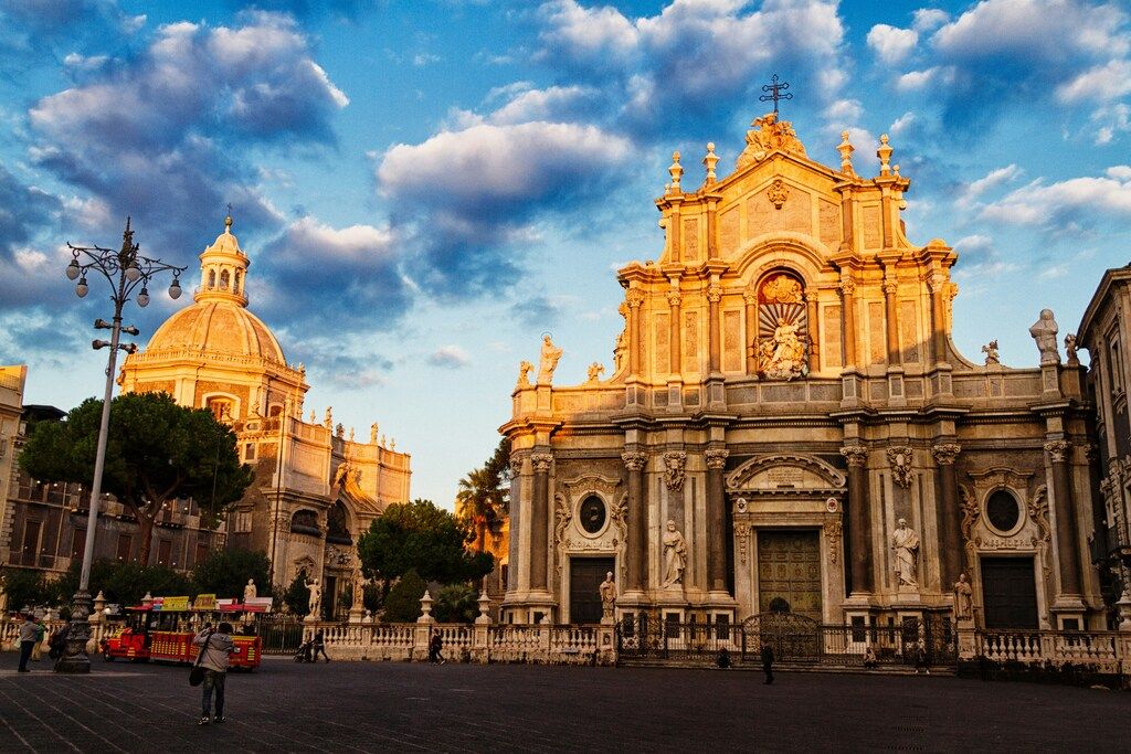 Die barocke Kathedrale von Catania in warmem Abendlicht mit dramatischem Himmel