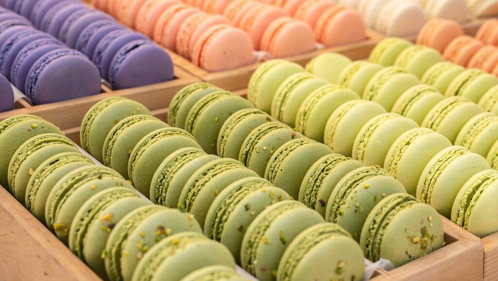 Reihen von bunten französischen Macarons in Holzkisten.