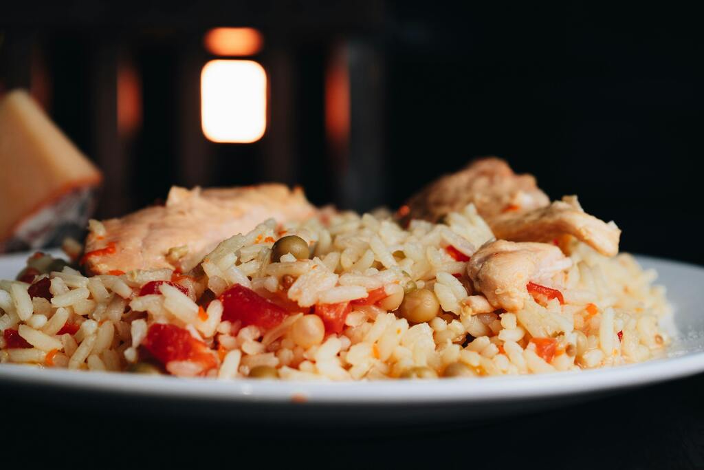 Teller mit Arroz con Pollo, einem beliebten Reisgericht mit Hähnchen, Erbsen und Paprika.