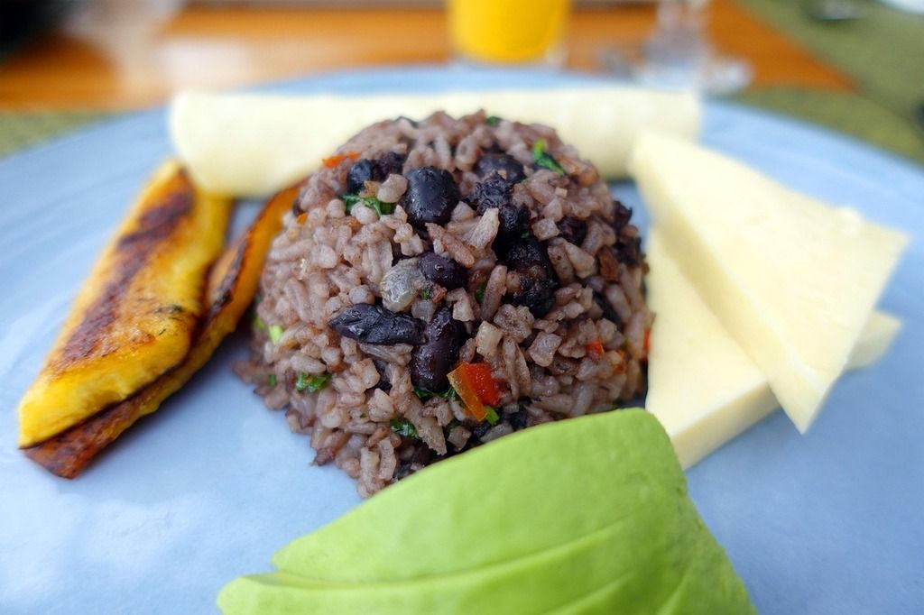 Traditionelles costa-ricanisches Frühstück mit Gallo Pinto, gebratenen Kochbananen, Avocado und Käse.