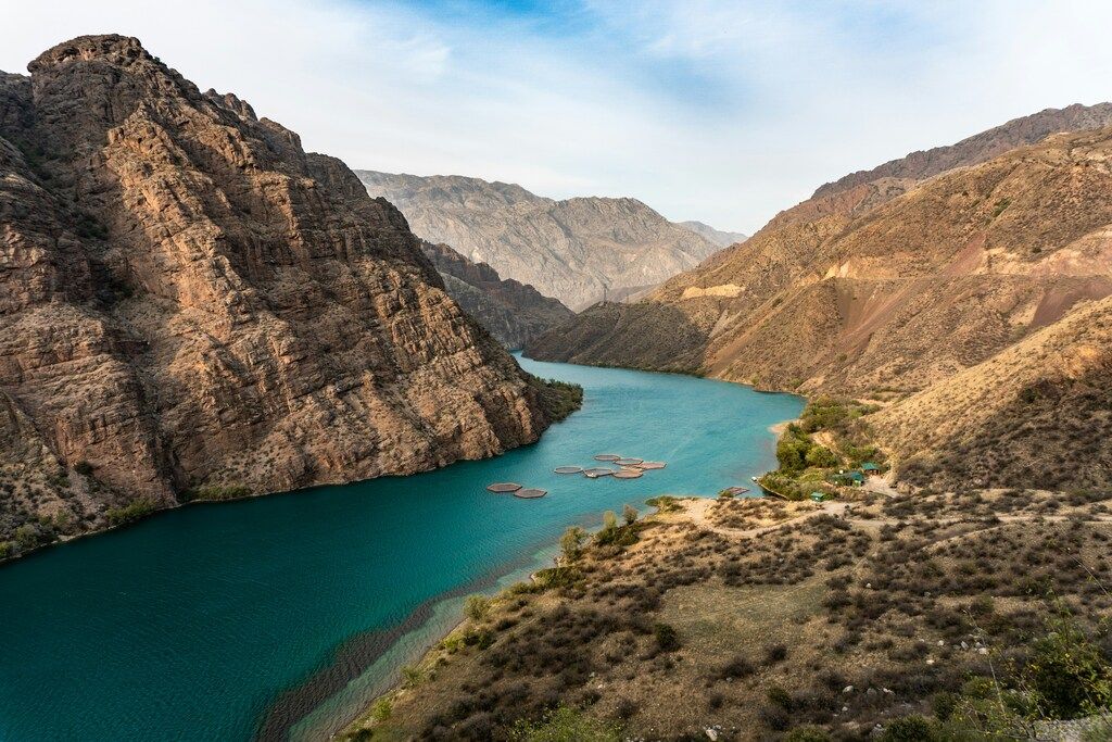 Tiefer Canyon mit türkisfarbenem Fluss, umgeben von kargen Berghängen – Naturwunder Kirgistans.