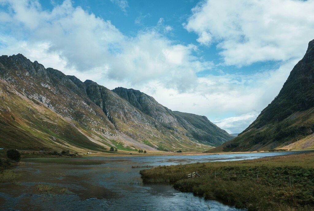 Flusstal von Glencoe an einem klaren Tag mit Bergen im Hintergrund