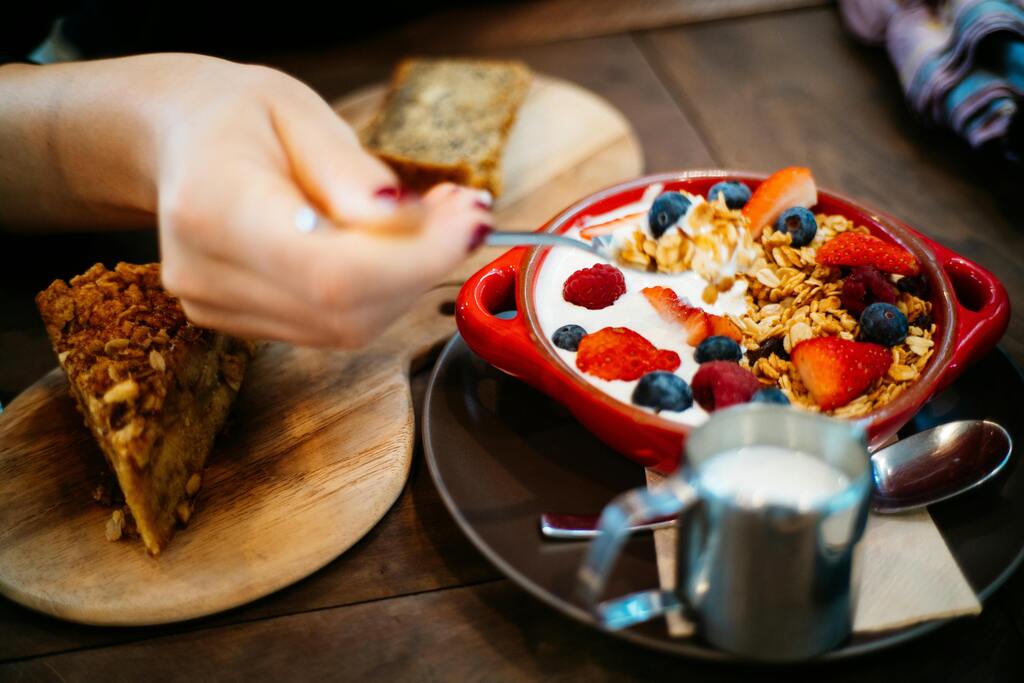 Frisches Frühstück mit Joghurt, Beeren und knusprigem Granola in einer roten Schale serviert