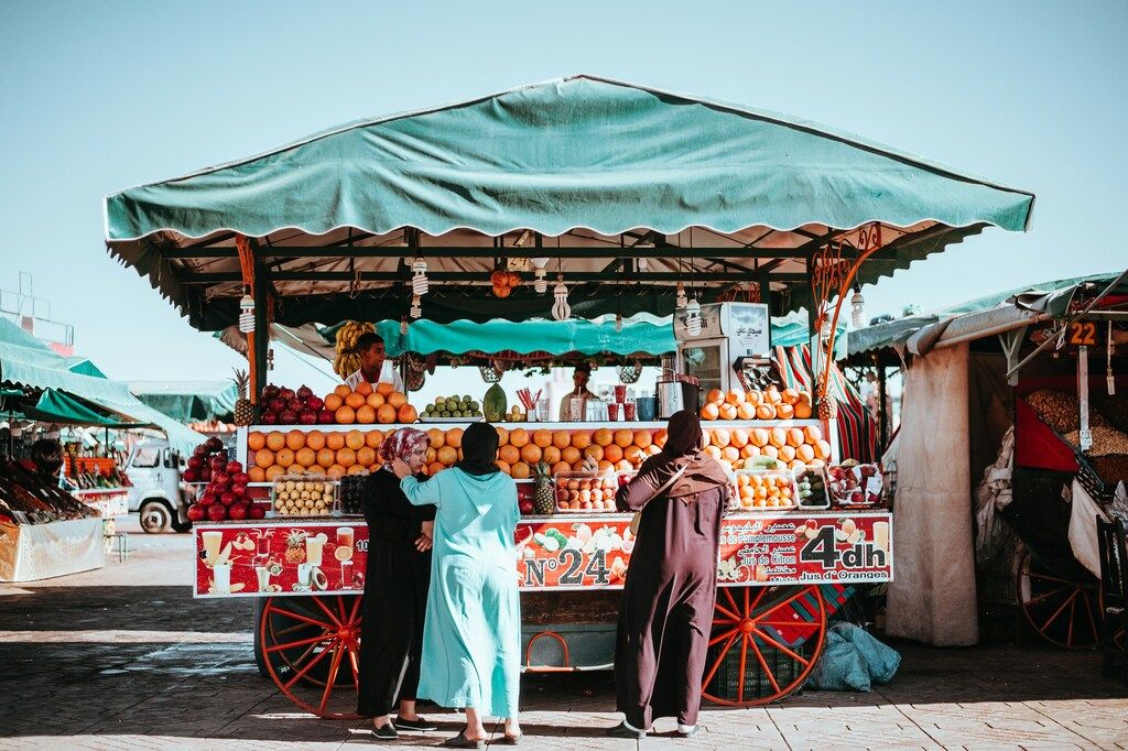 Straßenstand mit frischen Orangen und Granatäpfeln auf einem Markt in Marokko.