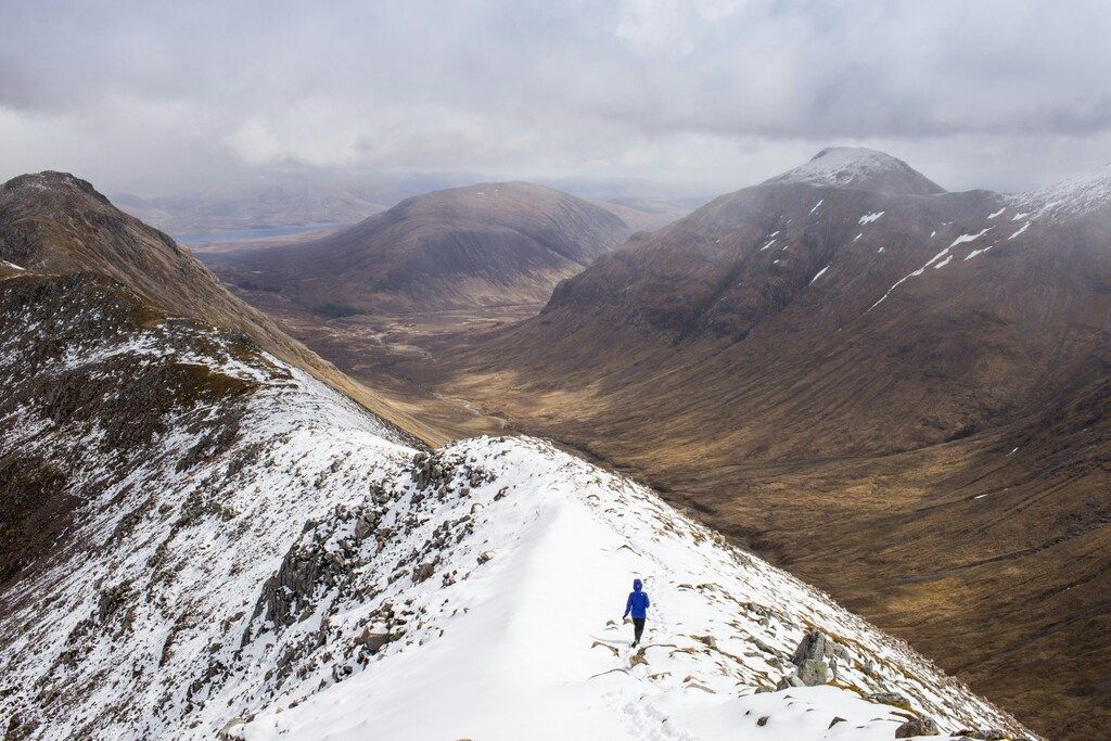 Wanderer auf einem verschneiten Grat in den schottischen Highlands