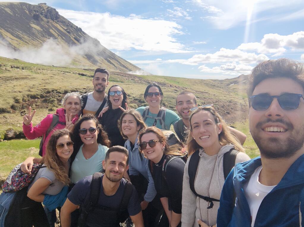 Fröhliche WeRoad-Reisegruppe beim Wandern in der malerischen Landschaft Islands