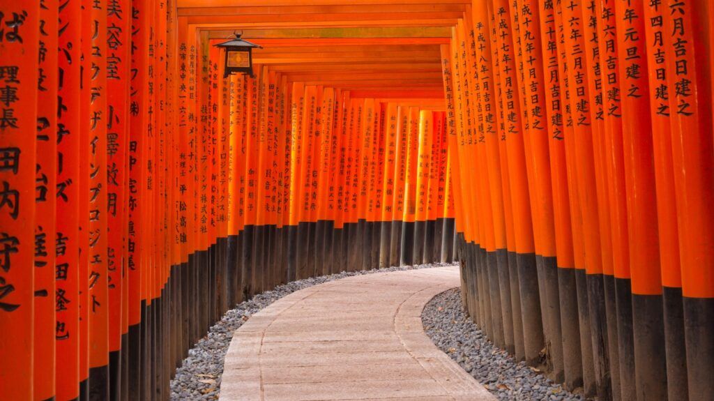 Pfad mit Tausenden von orangefarbenen Torii-Toren im Fushimi Inari-Schrein in Kyoto, Japan.