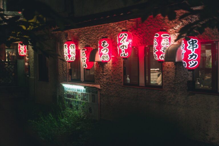 Japanisches Restaurant bei Nacht mit leuchtenden roten Laternen.