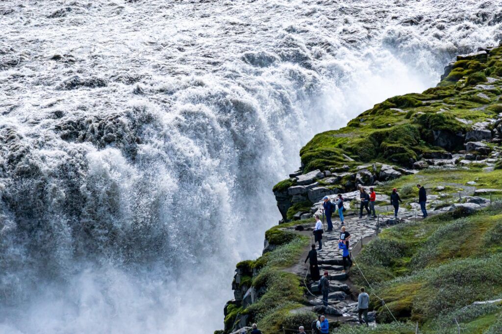 Dettifoss Wasserfall von oben mit Touristen am Rand der gewaltigen Wassermassen.