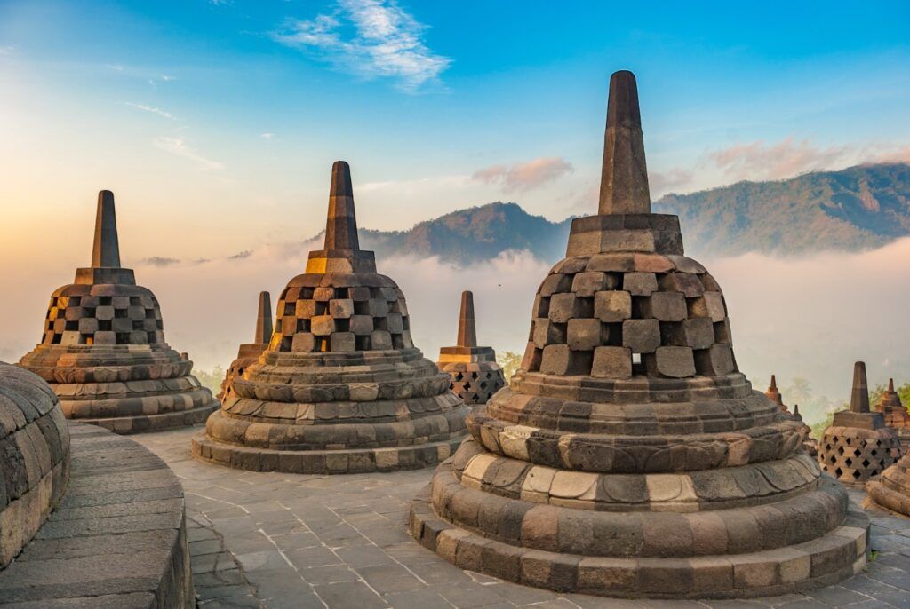 Stupas auf der obersten Ebene des Borobudur Tempels bei Sonnenaufgang über den Nebeln.