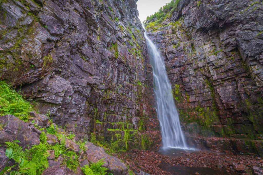 Die hohe Kaskade des Njupeskär-Wasserfalls stürzt von moosbewachsenen Felswänden herab.