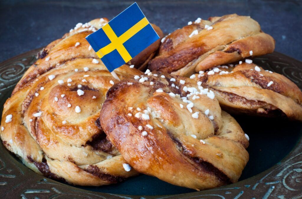 Kanelbullar (Zimtschnecken) mit schwedischer Flagge als Symbol für die traditionelle Fika-Pause.