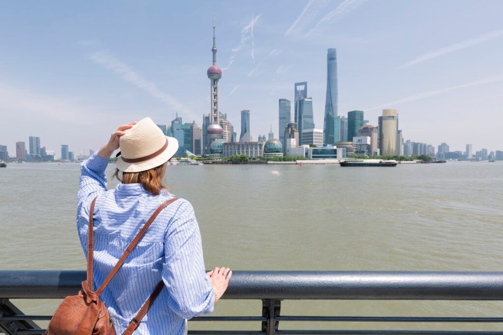 Tourist betrachtet die Skyline von Shanghai mit dem Oriental Pearl Tower.