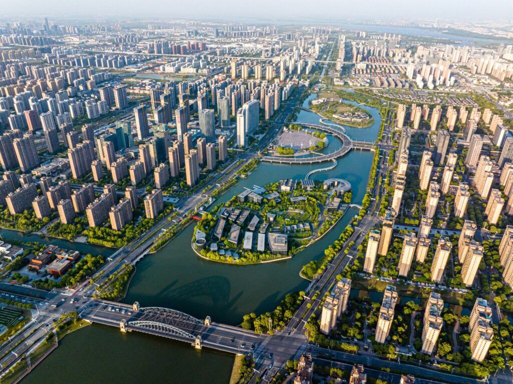 Vogelperspektive einer modernen chinesischen Stadt mit Wohnhäusern und Fluss.