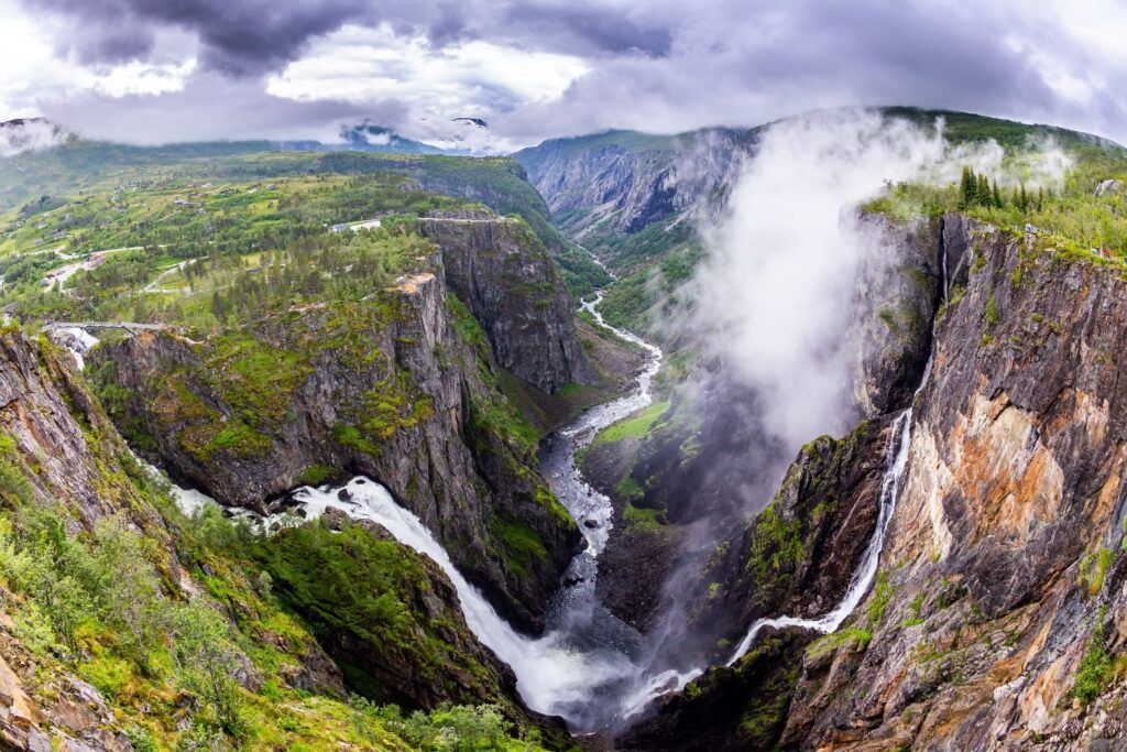 Der spektakuläre Wasserfall Vøringsfossen stürzt in eine tiefe Schlucht des Hardangerfjords in Norwegen, umgeben von nebligen Klippen.