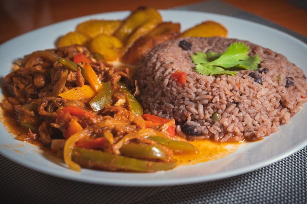 Ein traditionelles kubanisches Gericht mit Ropa Vieja (zerkleinertem Fleisch in Soße), serviert mit einer Portion Reis und schwarzen Bohnen sowie gebratenen Kochbananen.
