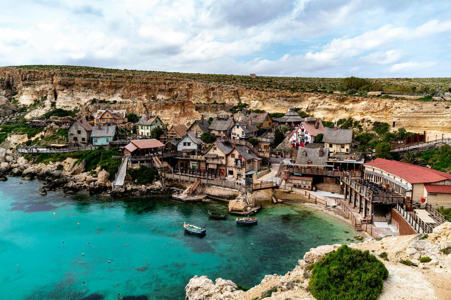 Popeye Village in der Anchor Bay auf Malta mit bunten Holzhäusern und türkisfarbenem Wasser