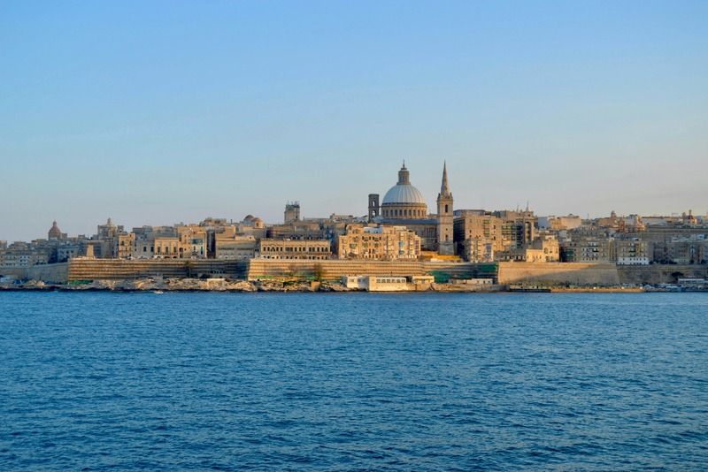 Skyline von Valletta bei Sonnenuntergang mit Karmeliterkirche und St. Pauls Kathedrale vom Wasser aus
