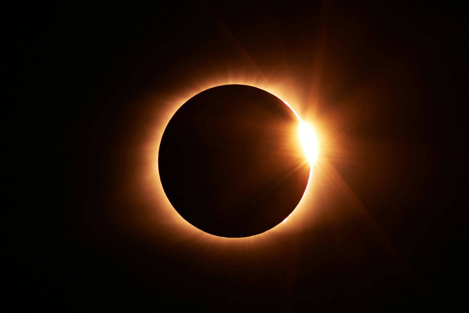 Totale Sonnenfinsternis mit Diamantring-Effekt, leuchtende Sonnenkorona am Rand des Mondes vor schwarzem Himmel
