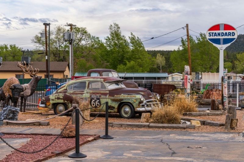 Vintage Auto im Route 66 Stil neben einem alten Schild