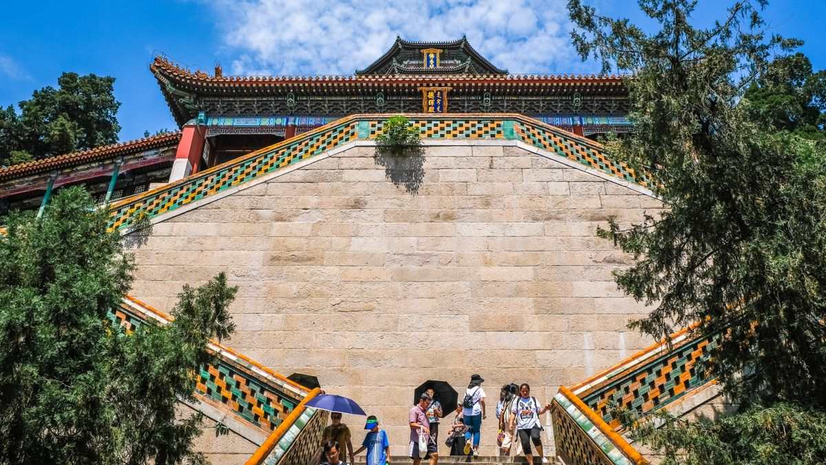 Besucher auf einer Treppe vor einem traditionellen Gebäude im Sommerpalast