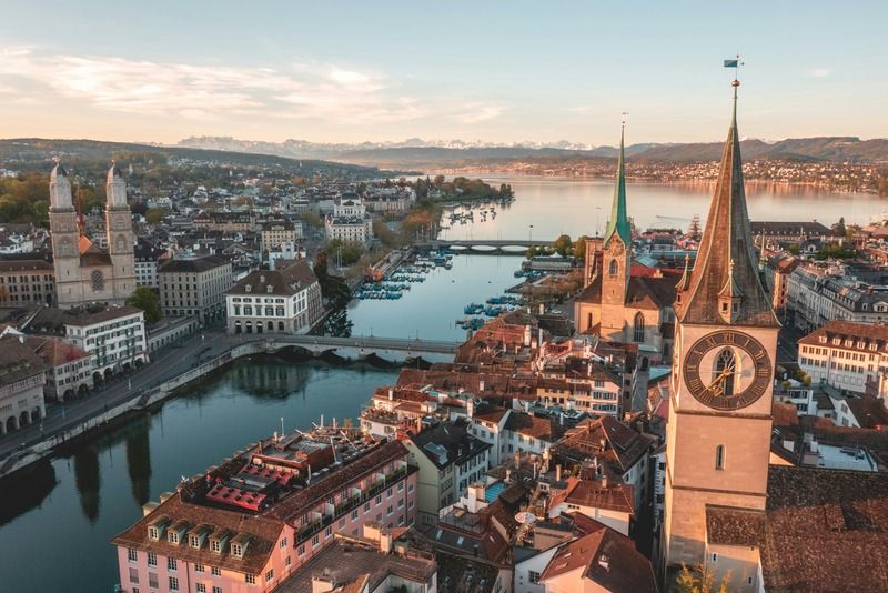 Luftaufnahme der Zürcher Altstadt bei Sonnenuntergang mit Kirchtürmen und der Limmat