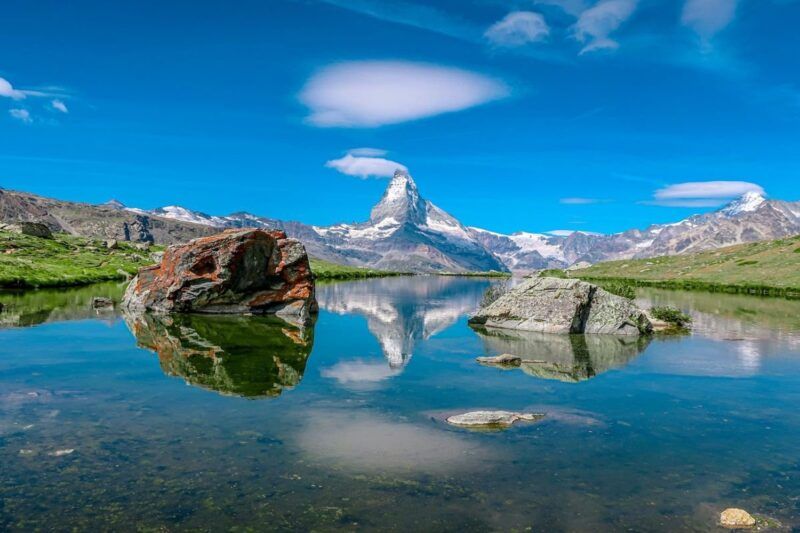Das Matterhorn spiegelt sich im ruhigen Wasser des Stellisees, umgeben von Felsen, in der Schweiz