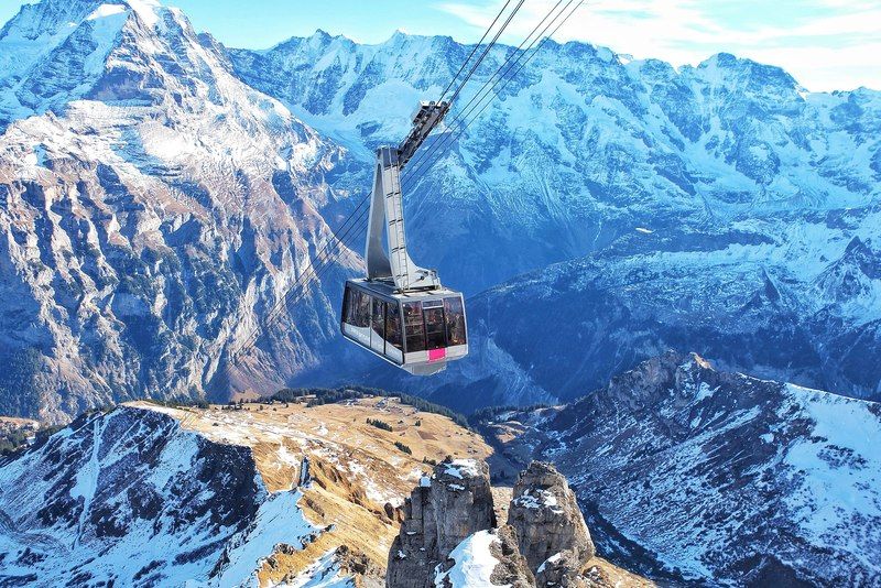 Seilbahn schwebt über schneebedeckte Berge in den Schweizer Alpen