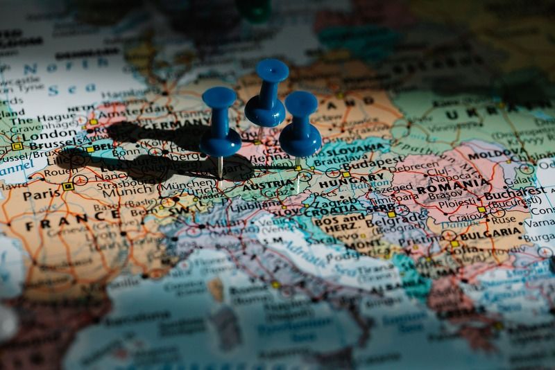 Drei blaue Stecknadeln markieren Reiseziele auf einer Karte Mitteleuropas