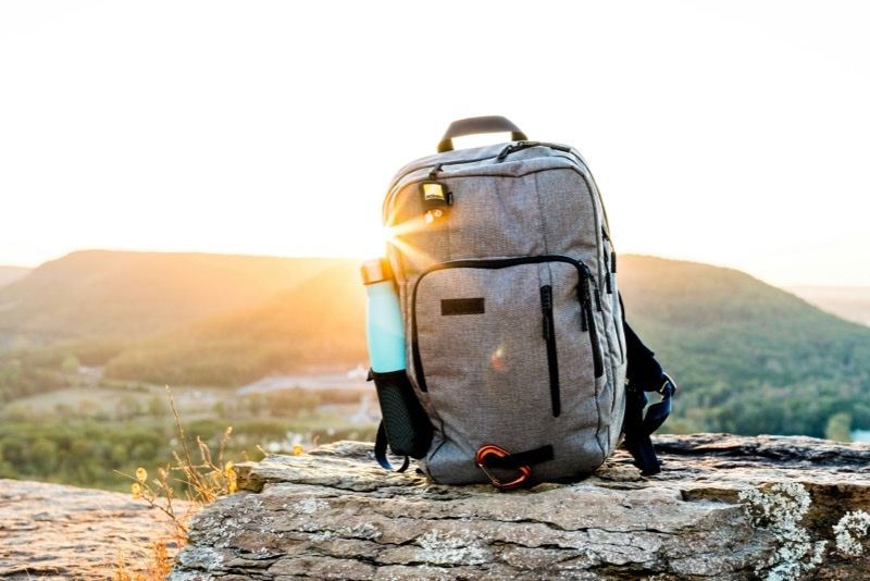 Rucksack auf einem Felsen bei Sonnenaufgang
