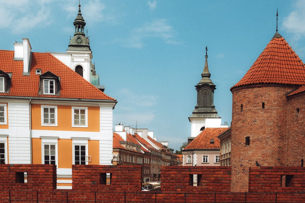 Backsteinturm, Stadtmauer und historische Häuser mit roten Dächern in der Warschauer Altstadt