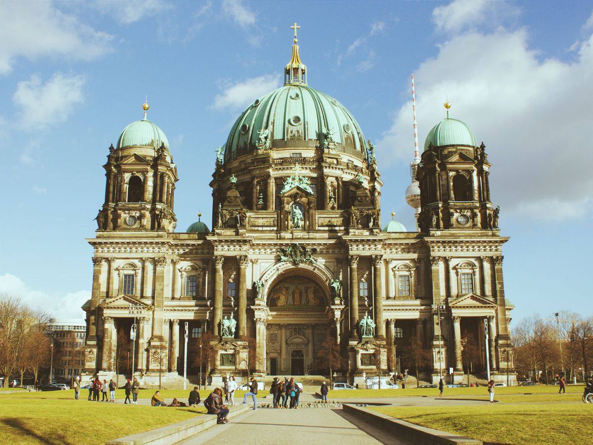 Berliner Dom mit großer Kuppel und zwei Türmen vor blauem Himmel