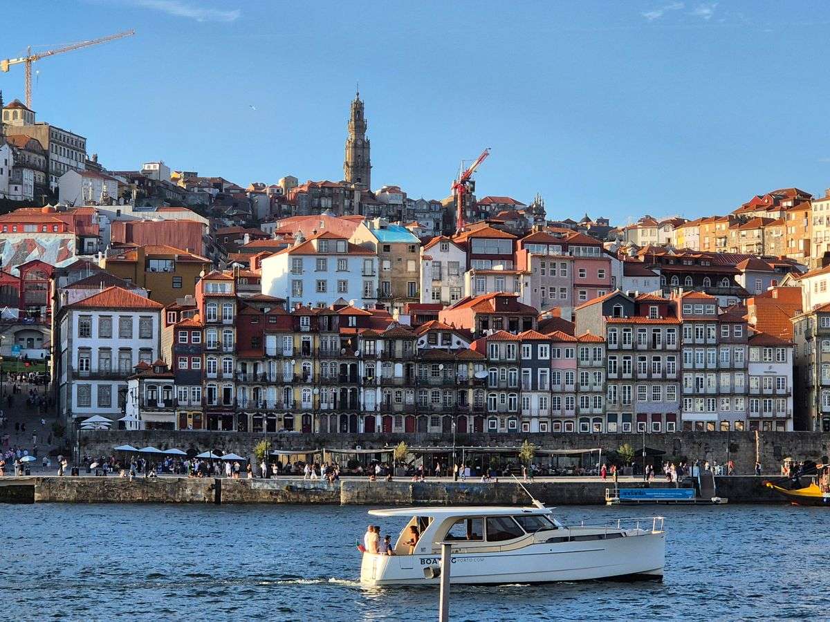 Historische Uferhäuser in Porto mit Boot auf dem Douro bei warmem Abendlicht