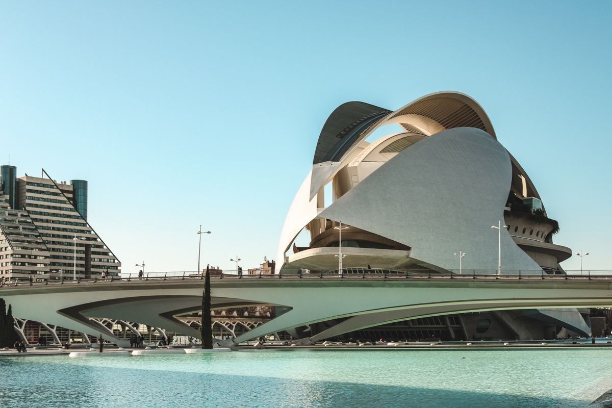 Palau de les Arts hinter einer Brücke und türkisfarbenem Wasser unter klarem Himmel
