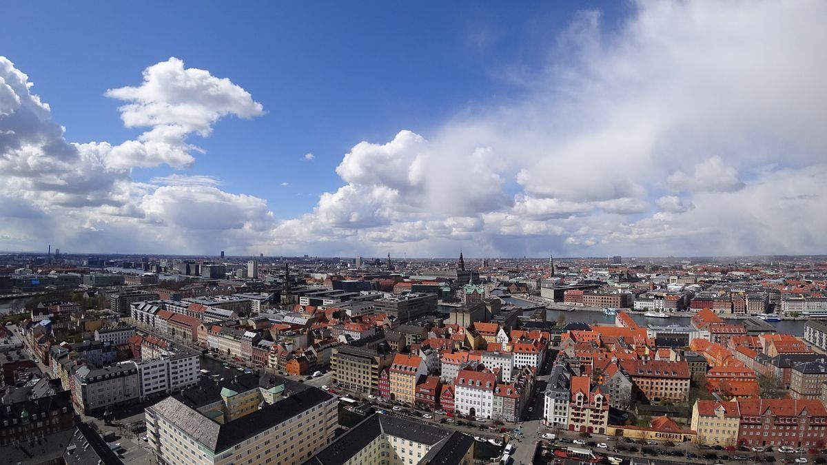 Panoramablick über Kopenhagen mit roten Dächern und großen Wolken am Himmel